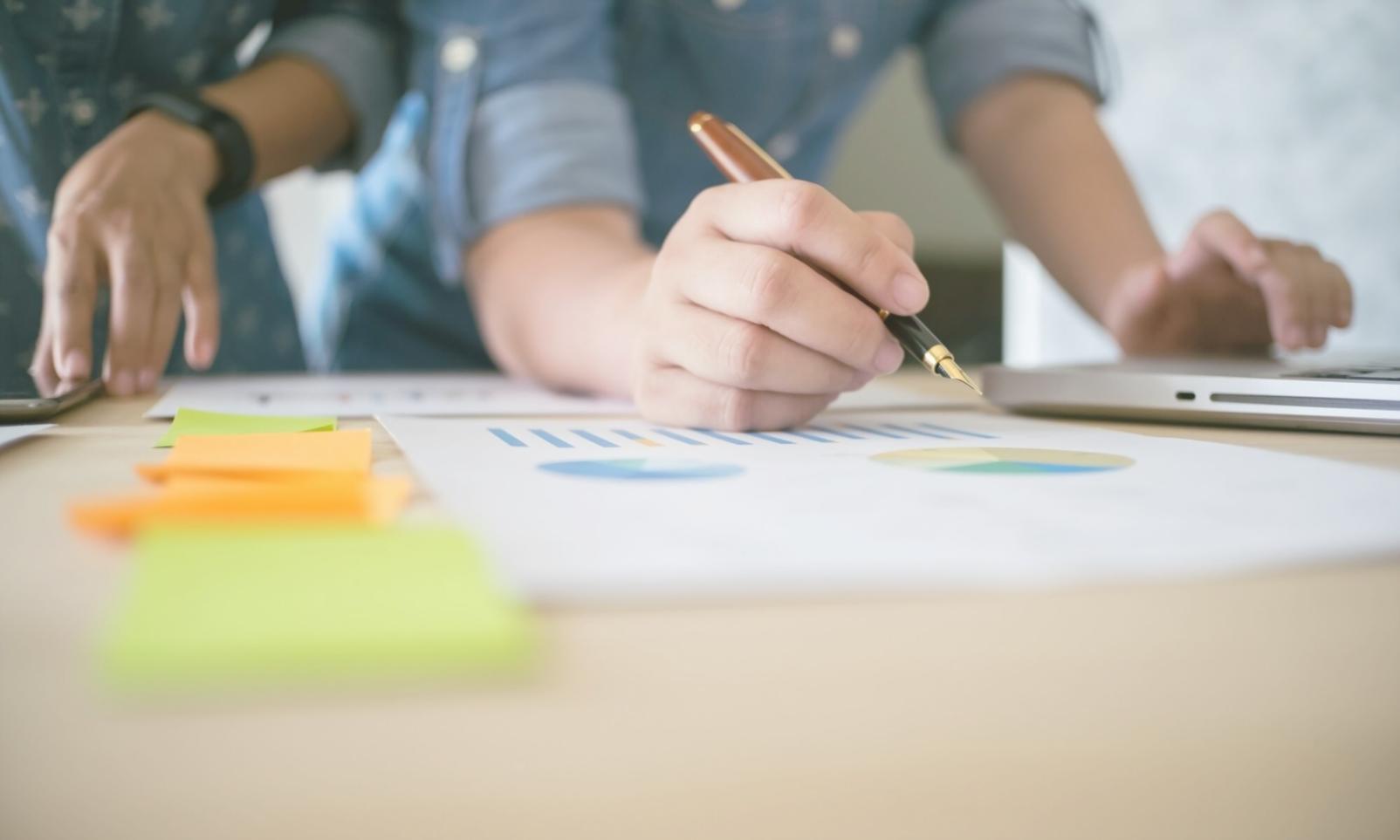 Business analysis workspace with financial charts and planning documents
